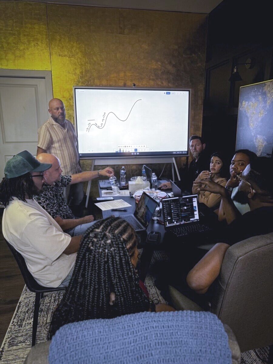 A church leadership team gathered around a screen during a One39 coaching workshop
